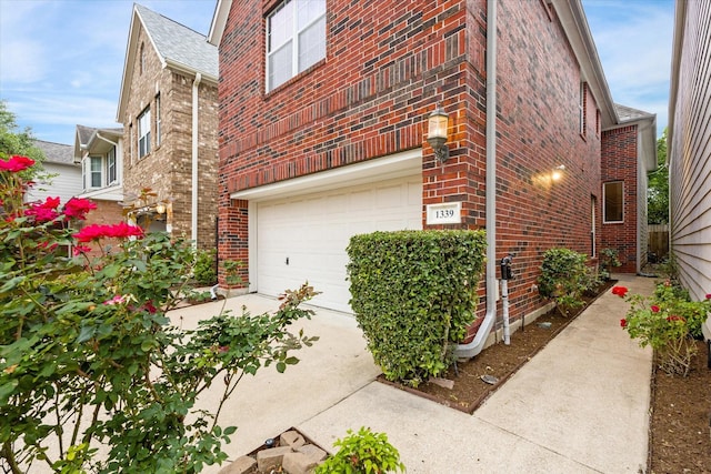 1339 Ella Pl, Houston, TX 77008 - view of home's exterior featuring a garage, brick siding, and concrete driveway