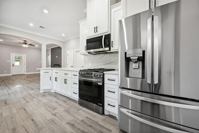 kitchen featuring recessed lighting, appliances with stainless steel finishes, light countertops, white cabinets, and crown molding