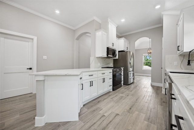 kitchen with white cabinetry, black gas range, arched walkways, and light stone counters