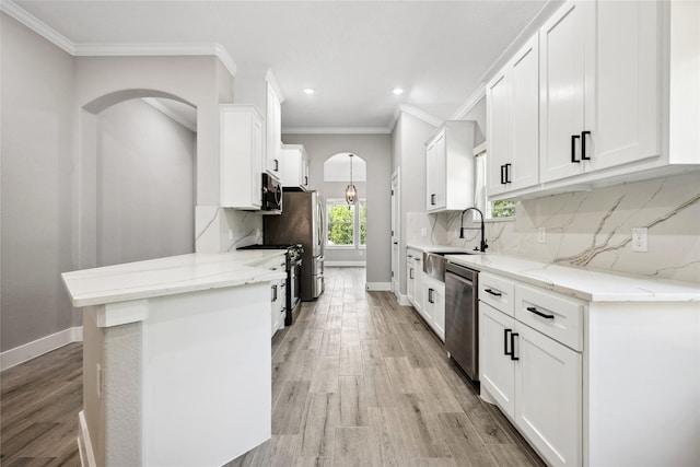 kitchen with white cabinetry, stainless steel appliances, crown molding, and a sink