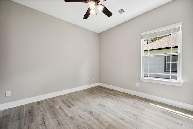 spare room featuring baseboards, visible vents, wood finished floors, and ceiling fan