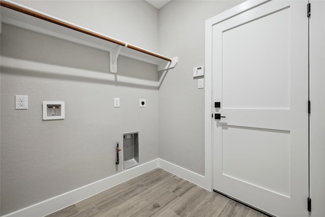 clothes washing area featuring hookup for a gas dryer, laundry area, light wood-type flooring, electric dryer hookup, and baseboards