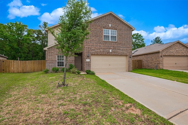 traditional home with a front yard, fence, an attached garage, and brick siding
