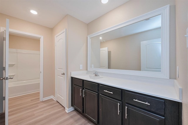 full bath featuring vanity, recessed lighting, wood finished floors, and baseboards