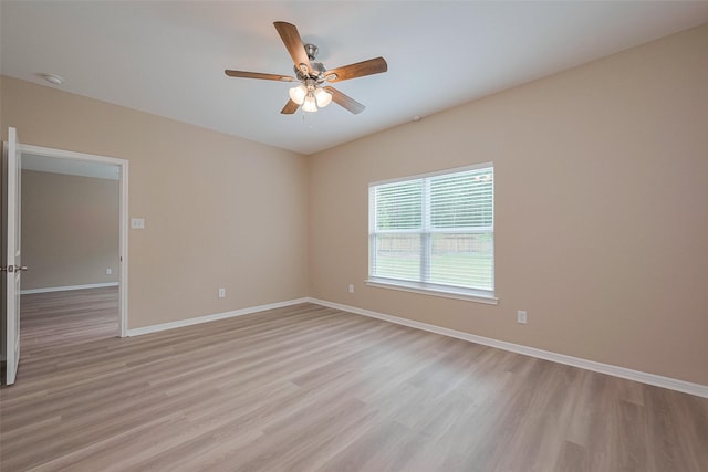 unfurnished room featuring a ceiling fan, light wood finished floors, and baseboards