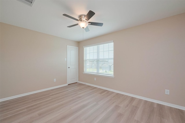 empty room featuring a ceiling fan, visible vents, baseboards, and light wood-type flooring