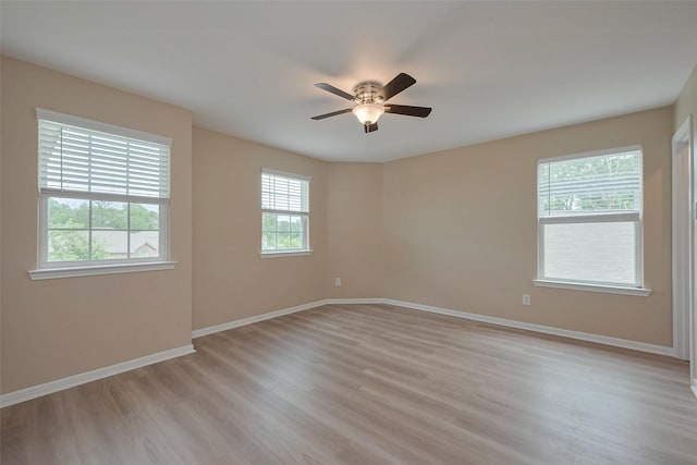 empty room with baseboards, ceiling fan, and light wood finished floors
