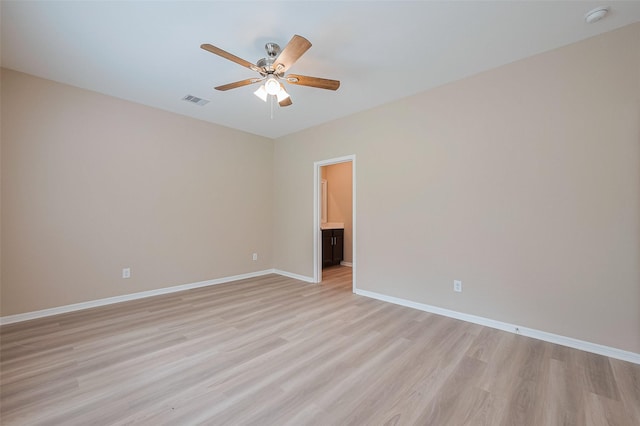 empty room with visible vents, ceiling fan, light wood-style flooring, and baseboards