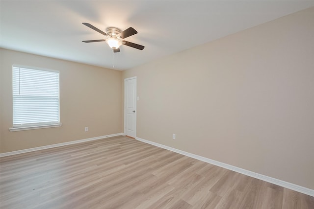 empty room featuring baseboards, a ceiling fan, and light wood-style flooring
