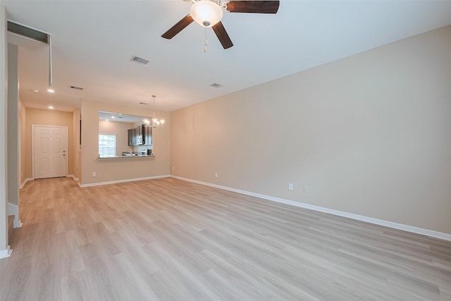 unfurnished room featuring light wood finished floors, visible vents, baseboards, and ceiling fan with notable chandelier