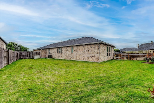 29031 Zacate Creek Ln, Fulshear, TX 77441 - rear view of house featuring a lawn, a fenced backyard, central air condition unit, and brick siding
