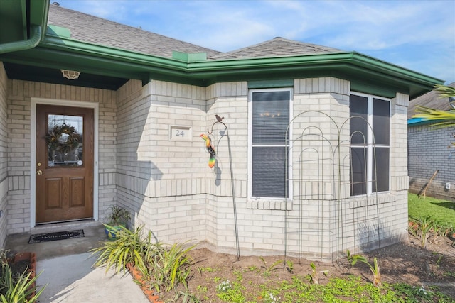 24 Clara Barton Ln, Galveston, TX 77551 - view of exterior entry with brick siding and a shingled roof