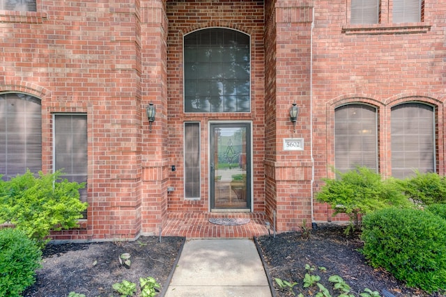 entrance to property featuring brick siding