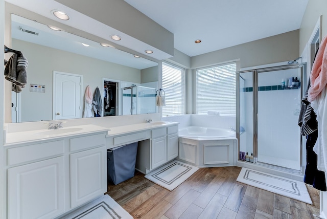bathroom featuring a shower stall, a sink, double vanity, visible vents, and a garden tub