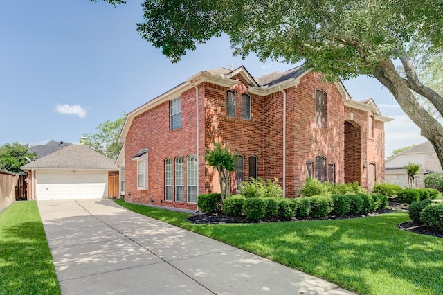 view of front of home with driveway, an outdoor structure, a front yard, brick siding, and a garage