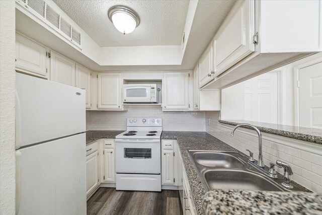10855 Meadowglen Ln Unit 1030, Houston, TX 77042 - kitchen featuring dark wood-style floors, a sink, white cabinetry, backsplash, and white appliances