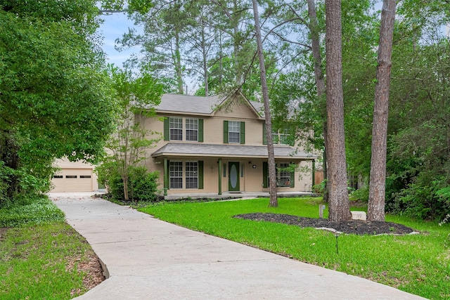view of front of house with a front yard, driveway, and covered porch