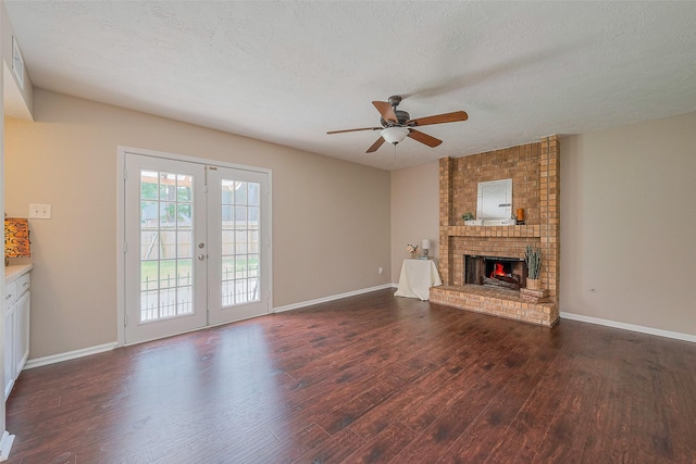 unfurnished living room featuring a fireplace, wood finished floors, a ceiling fan, baseboards, and french doors
