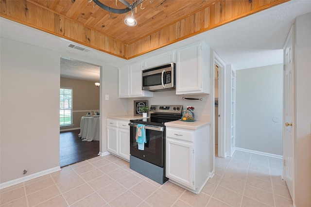 kitchen featuring wooden ceiling, stainless steel appliances, light tile patterned floors, light countertops, and visible vents