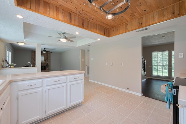 kitchen featuring wood ceiling, light countertops, visible vents, a raised ceiling, and a ceiling fan