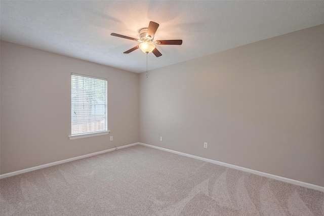 empty room with ceiling fan, light colored carpet, and baseboards