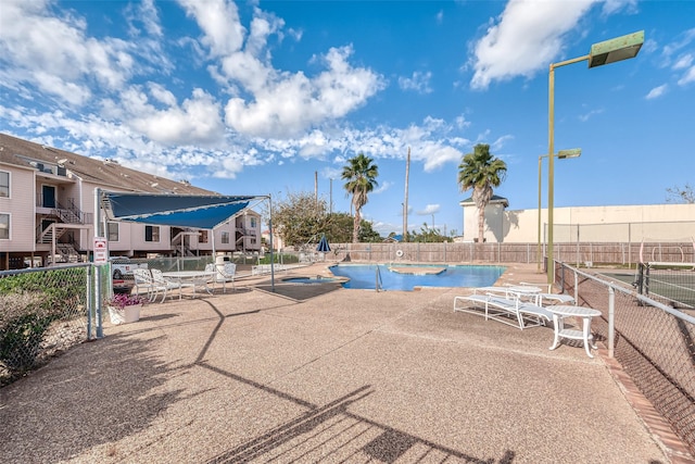 pool with fence and a patio area