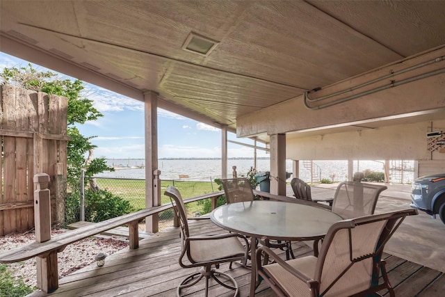deck featuring a water view, fence, and outdoor dining area