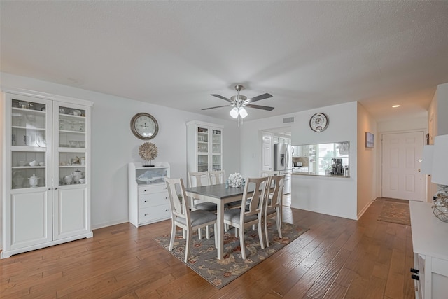 dining room featuring a ceiling fan, baseboards, visible vents, and hardwood / wood-style flooring
