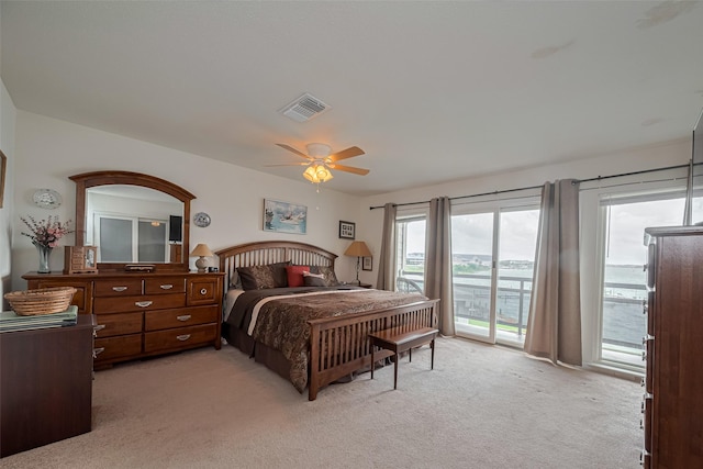 bedroom featuring access to outside, a ceiling fan, visible vents, and light carpet