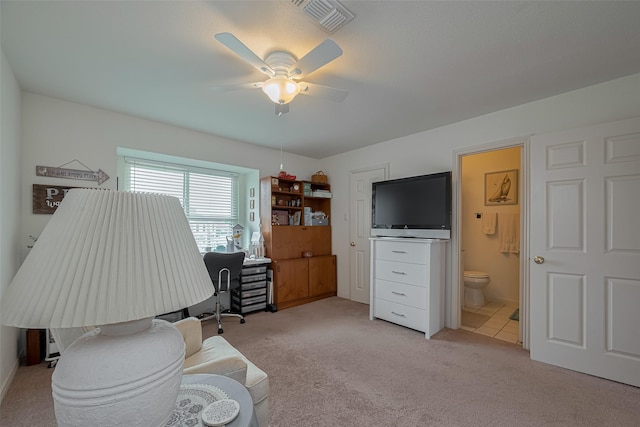 office space featuring ceiling fan, light carpet, and visible vents