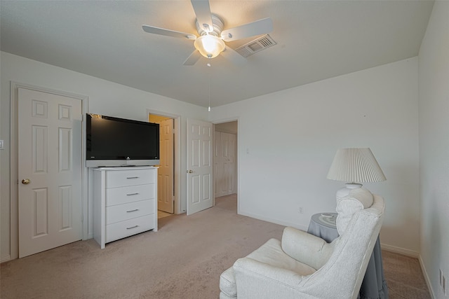 sitting room featuring visible vents, baseboards, ceiling fan, and light colored carpet