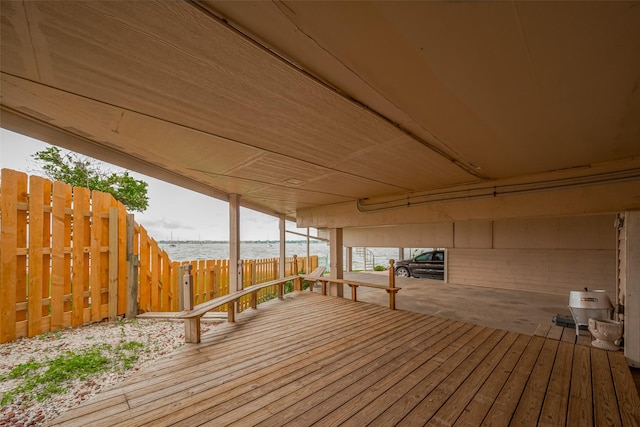wooden deck with a fenced backyard and a water view