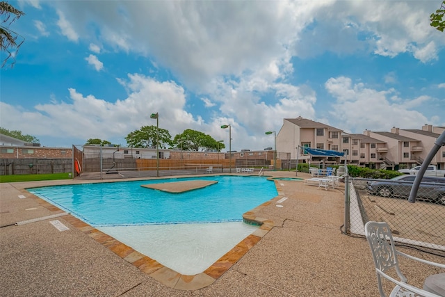 pool with fence and a patio area