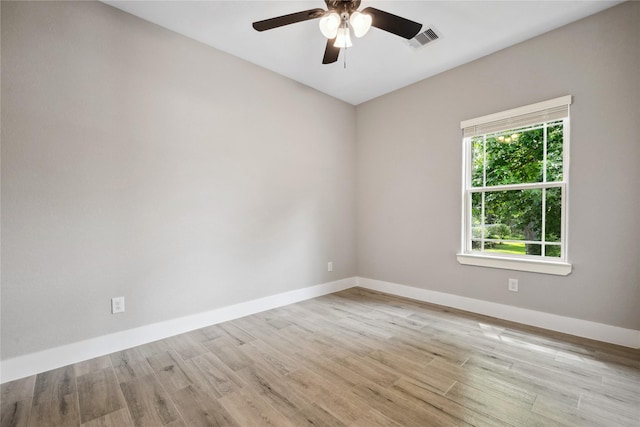 empty room with visible vents, a ceiling fan, light wood-style flooring, and baseboards