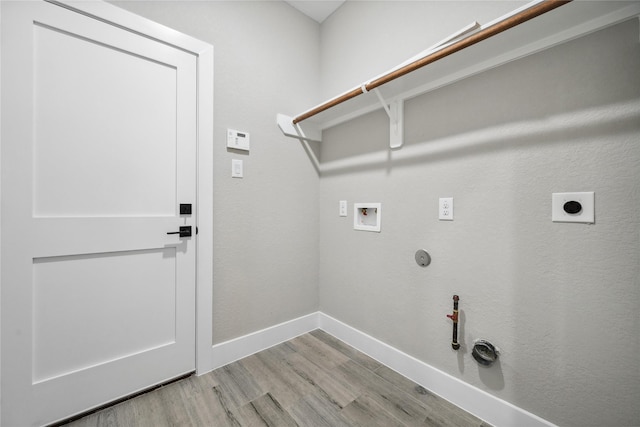 washroom with washer hookup, light wood-style flooring, hookup for a gas dryer, baseboards, and laundry area