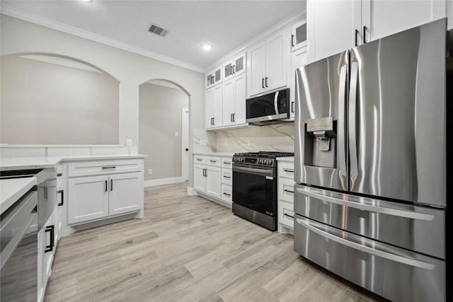 kitchen with recessed lighting, stainless steel appliances, light wood-type flooring, visible vents, and ornamental molding