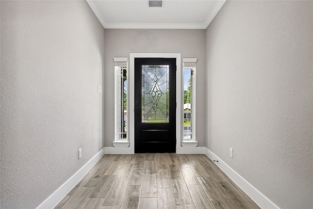 entryway featuring ornamental molding, visible vents, wood finished floors, and baseboards