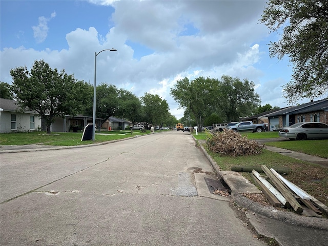 view of street with curbs, street lighting, and a residential view