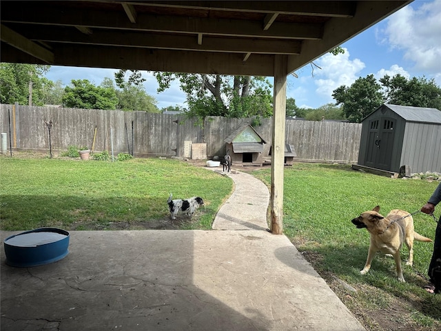 view of yard with a storage unit, an outbuilding, a patio, and a fenced backyard