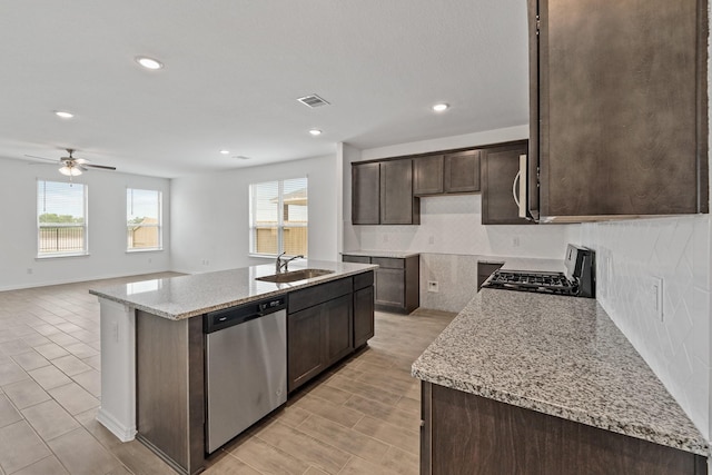 kitchen featuring gas stove, stainless steel dishwasher, a healthy amount of sunlight, dark brown cabinets, and a sink