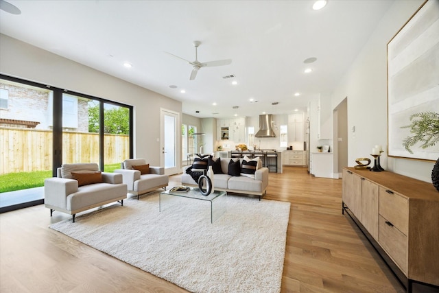 living area featuring ceiling fan, recessed lighting, visible vents, and light wood-style floors