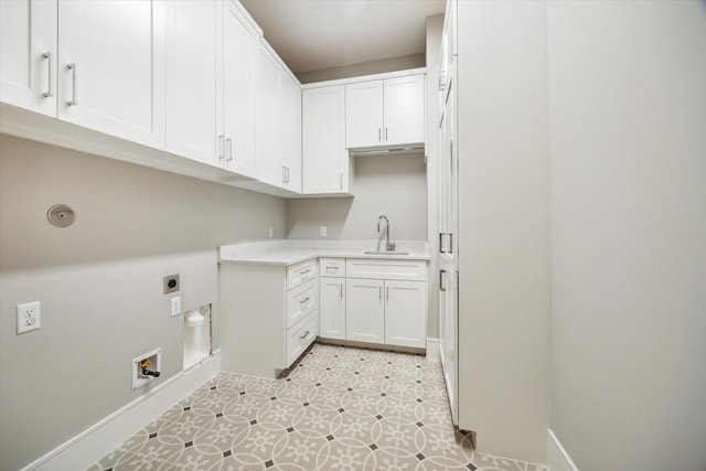 laundry area with baseboards, cabinet space, hookup for an electric dryer, and a sink