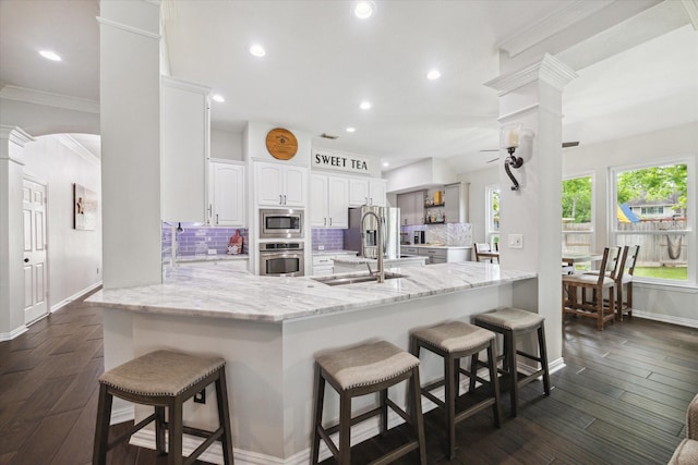 1603 Evening Bend Ct, Sugar Land, TX 77479 - kitchen with appliances with stainless steel finishes, ornate columns, a peninsula, a breakfast bar, and recessed lighting