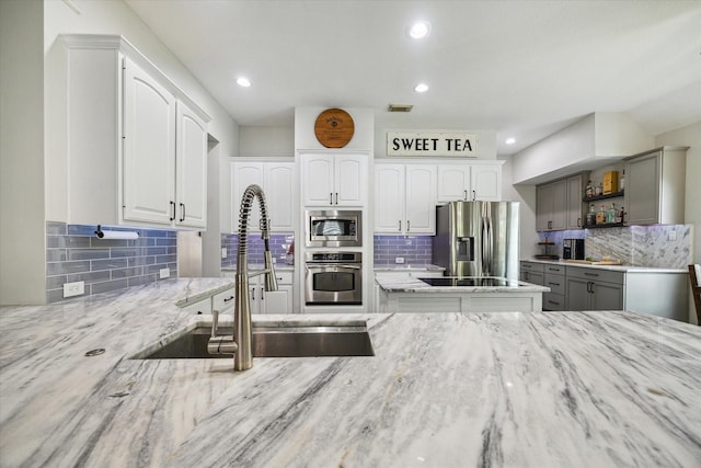 1603 Evening Bend Ct, Sugar Land, TX 77479 - kitchen with appliances with stainless steel finishes, a sink, tasteful backsplash, light stone counters, and open shelves