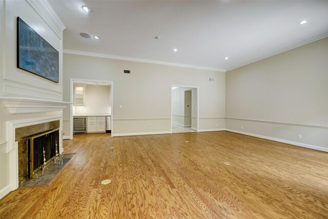 4856 Post Oak Timber Dr, Houston, TX 77056 - unfurnished living room featuring light wood-style floors, a high end fireplace, baseboards, ornamental molding, and wine cooler