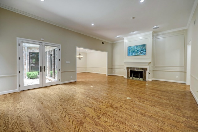 4856 Post Oak Timber Dr, Houston, TX 77056 - unfurnished living room featuring an inviting chandelier, a fireplace with flush hearth, crown molding, light wood-style flooring, and french doors