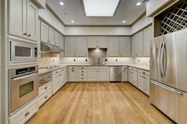 4856 Post Oak Timber Dr, Houston, TX 77056 - kitchen with stainless steel appliances, under cabinet range hood, light countertops, light wood finished floors, and a sink
