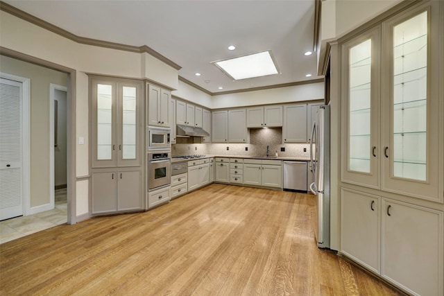 4856 Post Oak Timber Dr, Houston, TX 77056 - kitchen featuring a sink, stainless steel appliances, under cabinet range hood, crown molding, and backsplash