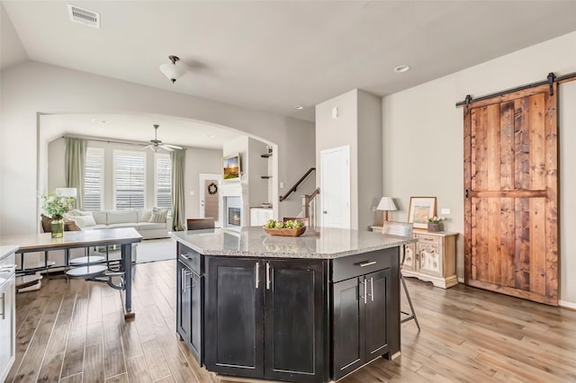 kitchen featuring arched walkways, light wood-style flooring, visible vents, and a ceiling fan