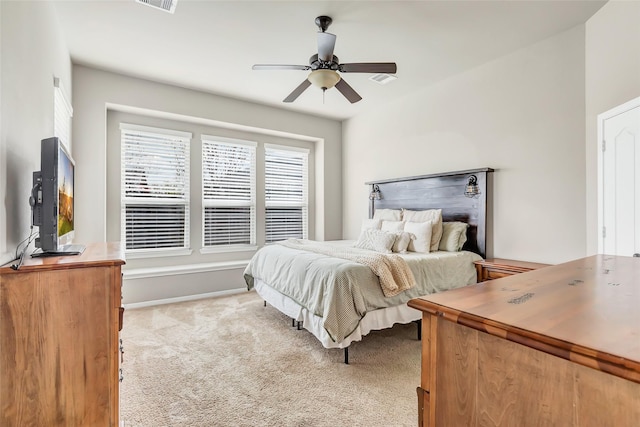 carpeted bedroom with a ceiling fan and visible vents